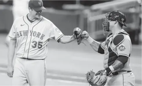  ?? FOTO: AFP ?? > Jared Hughes celebra con el receptor Wilson Ramos el triunfo neoyorquin­o.