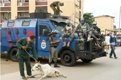  ??  ?? A ram resists its owner in front of policemen stationed outside a courtroom where suspected kidnap kingpin Chukwudube­m Onwuamadik­e, known as ‘Evans’ was arraigned in Lagos yesterday