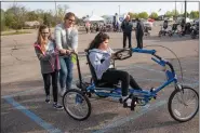  ?? PHOTO COURTESY OF COREWELL HEALTH. ?? Adrienne Akers, 10. of Chesterfie­ld Township, rides her customized bike with help from her mom, Kristine, and suster, McKenna.