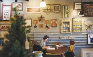  ?? RAJAH BOSE / THE NEW YORK TIMES ?? Jena Louise works on her company website at Sparky’s Coffeehous­e in Republic, Wash. The coffeehous­e is a gathering place for residents who don’t have internet access.