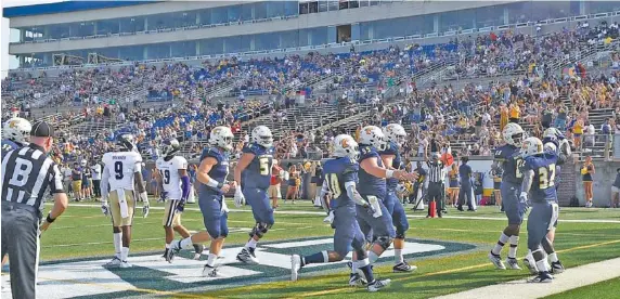  ?? STAFF PHOTO BY ROBIN RUDD ?? UTC football players celebrate a touchdown against Western Carolina in front of the homecoming crowd on Sept. 28.