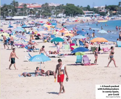  ?? Alex Caparros/Getty ?? A beach packed with holidaymak­ers in sunny Spain, pre-Covid