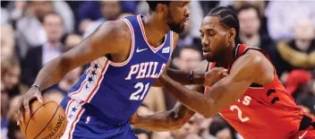  ?? FRANK GUNN/THE CANADIAN PRESS ?? The Raptors’ Kawhi Leonard, right, defends against the 76ers’ Joel Embiid.