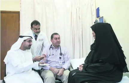  ?? Mona Al Marzooqi / The National ?? From left, Dr Ali Obaidli, chair of the National Transplant Committee, Dr Muhammad Zaman, head of transplant­ation services at Sheikh Khalifa Medical City and Dr Nizar Attallah, consultant nephrologi­st, Cleveland Clinic Abu Dhabi with Fatima Al Blooshi.