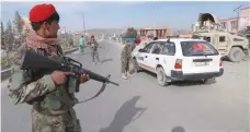  ?? — AFP ?? Afghan security personnel search passengers in a checkpoint on Highway One in Ghazni on October 29.