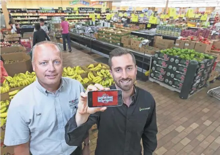  ??  ?? Jeremy Neren (right), founder and CEO of GrocerKey, shows the app in 2015 with Woodman's store manager Dale Martinson as the companies were beginning work on Woodman’s online grocery service.