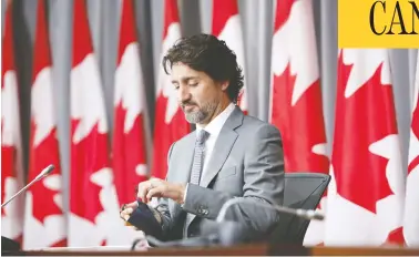  ?? DAVID KAWAI / BLOOMBERG ?? Prime Minister Justin Trudeau prepares for a news conference in Ottawa Wednesday, where the first estimate
was released of the full cost of the effort to buffer Canada from its deepest recession since the 1930s.