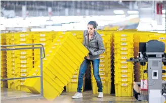  ?? AFP ?? BELOW
A woman works at a fulfilment centre on Staten Island.