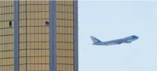  ?? (Reuters) ?? AIR FORCE ONE departs Las Vegas on Wednesday, past the broken windows of the Mandalay Bay Hotel