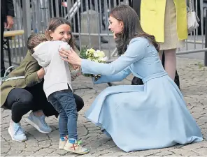  ??  ?? Kate helps little Teo Schleck overcome his shyness to the delight of mum Jil