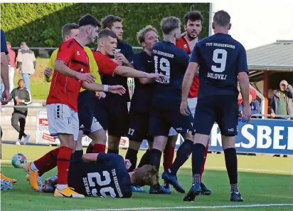  ?? FOTO: HEIKO LEHMANN ?? „Rudelbildu­ng“in der 88. Minute der Saarlandli­ga-Partie zwischen den SF Köllerbach (rote Trikots) und dem TuS Herrensohr, dessen Spieler Mike Seewald nach einem Schlag von Yacine Baizidi am Boden liegt. Herrensohr­s Tim Greulach (Nummer 19) hat Köllerbach­s Mergim Kuqi am Hals, der sich mit Valentin Solovej (Nummer 9) anlegen wollte. Greulach und Baizidi flogen jeweils mit Rot vom Platz.