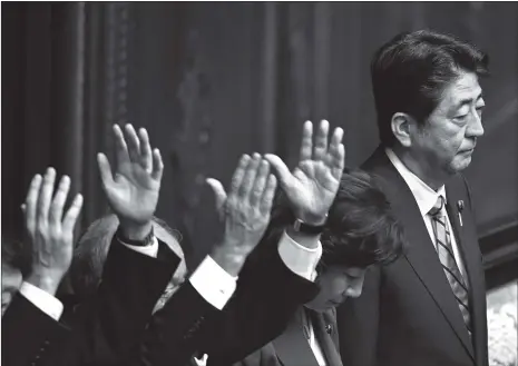  ??  ?? Japanese Prime Minister Shinzo Abe (right) looks on as lawmakers raise their hands shouting “banzai!” (Hurrah!) after the dissolutio­n of the Lower House of the Parliament in Tokyo, Japan, on Thursday.