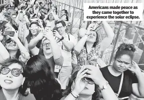  ??  ?? Americans made peace as they came together to experience the solar eclipse.