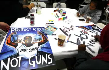  ??  ?? Young activists paint signs to be carried at the upcoming ‘March for Our Lives’ in Los Angeles. — AFP photo