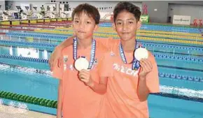  ?? PIC BY SOLOMON SAMUEL ?? Boys’ Under-12 1m gold winner Soh Tze Kang (left) and Eilisha Rania.
