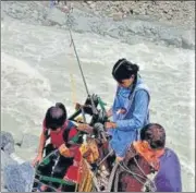  ?? HT PHOTO ?? Schoolchil­dren cross a fast-flowing river using a rope to reach their schools in Bangapani, Pithoragar­h district.