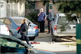  ?? AP-Gary Kazanjian ?? Fresno police Investigat­or Brooke Passmore, left, works on the driveway on Lamona Avenue where a shooting took place at a house party which involved multiple fatalities and injuries in Fresno, Calif., on Monday.