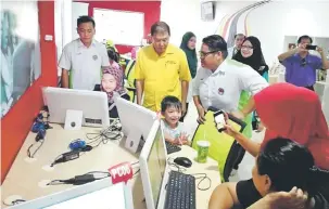  ??  ?? CELIK IT: Sebastian (baju kuning) melihat penduduk Piasau memanfaatk­an Pusat Internet 1 Malaysia Piasau semalam.