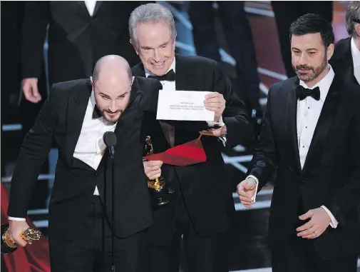  ?? — THE ASSOCIATED PRESS FILES ?? Jordan Horowitz, producer of La La Land, shows the envelope revealing Moonlight as the true winner of best picture at the Oscars as presenter Warren Beatty and host Jimmy Kimmel, right, look on last February.