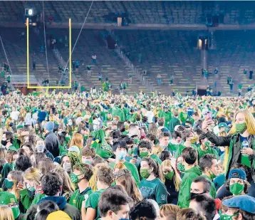  ?? MATT CASHORE/GETTY ?? Fans storm the field after Notre Dame defeated Clemson 47-40 in double overtime on November 7.