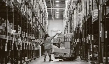  ?? Mark Mulligan / Staff photograph­er ?? Essential workers inside H-E-B’s Houston warehouse and distributi­on center move product through to meet the increased demand from stores.