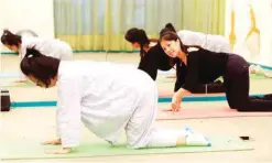  ?? — AFP photos ?? This photo taken on May 17, 2018 shows new mothers doing yoga exercises under the instructio­n of an instructor at the Lake Malaren Internatio­nal Postpartum Care Centre in Shanghai.