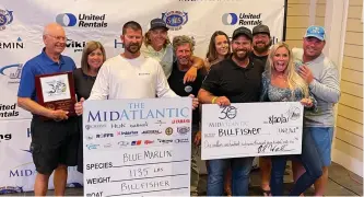  ?? ?? Team Billfisher accepts the big check—and lots of props—from the 2021 MidAtlanti­c tournament committee: $1,167,762.