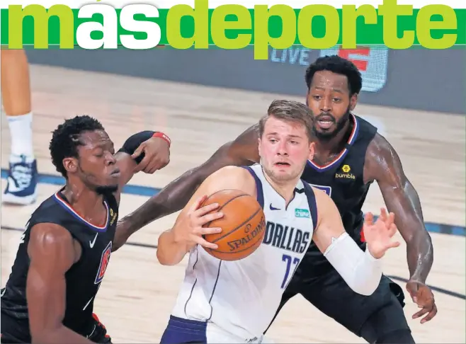  ??  ?? Doncic, defendido por Jackson y Green, de los Clippers, durante el segundo partido de la primera ronda de playoffs, en Florida.