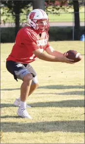  ??  ?? Junior quarterbac­k Kade Smith looks to hand off the ball during practice.