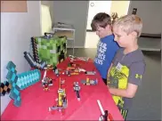  ??  ?? Luke Blevins (blonde) and Ethan Miller look at their LEGO builds from Summer Camp 2017.