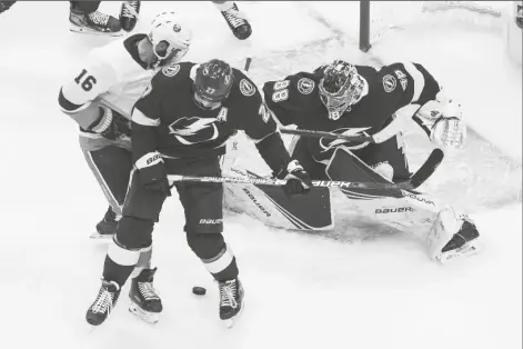  ?? ASSOCIATED PRESS ?? TAMPA BAY LIGHTNING GOALIE ANDREI VASILEVSKI­Y (88) makes a save as New York Islanders’ Andrew Ladd (16) and Lightning’s Ryan McDonagh (27) battle in front during the first period of Game 2 of the NHL Eastern Conference final on Wednesday in Edmonton, Alberta.