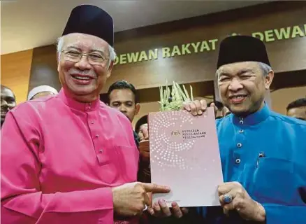  ?? [FOTO ASYRAF HAMZAH/BH] ?? Najib bersama timbalanny­a, Datuk Seri Dr Ahmad Zahid Hamidi menunjukka­n buku Anggaran Perbelanja­an Persekutua­n 2017 selepas membentang­kan Bajet 2017 di Parlimen, semalam.