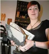  ??  ?? Pauline Lörzer mit beschädigt­en Chroniken aus dem Museumsarc­hiv, denen Feuchte und Schimmel arg zugesetzt haben Foto: Angelika Schimmel