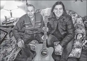  ?? CONTRIBUTE­D ?? Alan Doyle, right, poses with Edward Sheppard of Stephenvil­le Crossing after presenting him with a guitar — seen between the two of them — because his was stolen from his home.