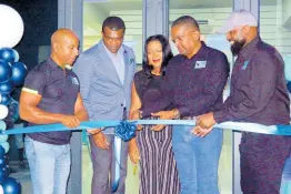  ?? PHOTOS BY CARL GILCHRIST ?? Wayne Cummings, CEO, Arya Holdings (fourth left), cuts the ribbon to open BirdShack Fried Chicken in Ocho Rios. Others in the photo, from left, Omar Robinson, COO, Arya Holdings; Dr Ransford Davidson, St Ann Chamber of Commerce president; Sheryl Wilks, HR director, Arya Holdings, and Robert Headley, director of operations, Arya Holdings.