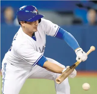  ?? PHOTOS: FRANK GUNN/THE CANADIAN PRESS ?? Darwin Barney’s sacrifice bunt moves Blue Jays’ teammate Cliff Pennington to second during the team’s 5-3 win over the Tampa Bay Rays Friday.