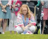  ?? JESSICA HILL/SPECIAL TO THE COURANT ?? Emma Hunt places flowers on a stone bearing the name of her father, William Christophe­r Hunt, at a 9/11 ceremony Thursday at Sherwood Island State Park in Westport. William Hunt was killed in the south tower of the World Trade Center.