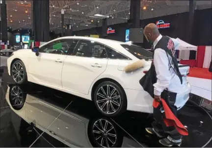  ?? DAVID S. GLASIER — THE NEWS-HERALD ?? Cleveland Auto Show attendant does final prep work on a 2019 Toyota Avalon.