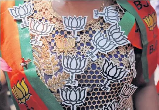  ??  ?? PINNED DOWN: A supporter of India’s ruling BJP wears pins with the party’s symbol as she celebrates the poll results of Karnataka state assembly vote.