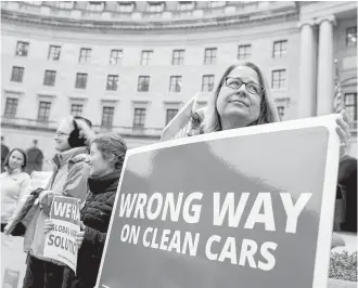  ?? Andrew Harnik / Associated Press ?? Protesters with Environmen­t America air their views outside the EPA as agency Administra­tor Scott Pruitt holds a news conference on his scrapping of Obama administra­tion fuel standards.