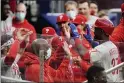  ?? JOHN BAZEMORE - THE ASSOCIATED PRESS ?? Phillies’ centerfiel­der Odubel Herrera is greeted at the dugout by teammates after hitting a three-run home run in the first inning Friday night in Atlanta. Saturday night’s game ended too late for this edition.