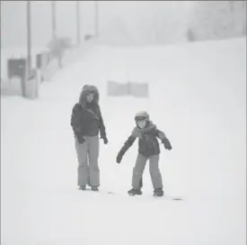  ?? HANNAH YOON ?? Deborah Attwood helps her son Parker, 8, snowboard at Chicopee Ski Club in Kitchener on Saturday.