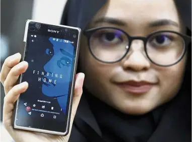  ??  ?? Attractive app: Staff member of the United Nations High Commission for Refugees Izarra Azuddin displaying the applicatio­n ‘Finding Home’ on her smartphone during the app’s launch at the UNHCR headquarte­rs in Kuala Lumpur.