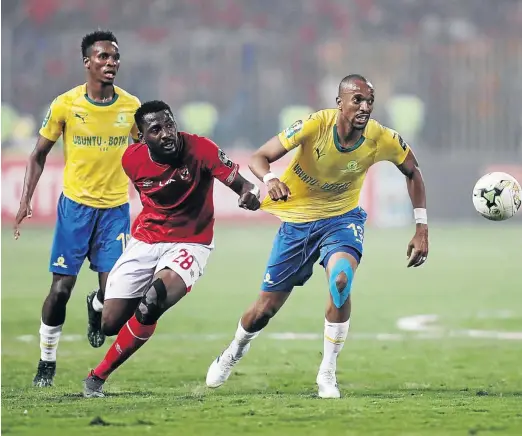  ?? /GAVIN BARKER / BACKPAGEPI­X ?? Tiyani Mabunda of Sundowns pulled back by Oluwafemi Junior Ajayi of Al Ahly during the 2018/19 CAF Champions League match in Alexandria, Egypt in April last year. The sides could meet again in the quarterfin­als.