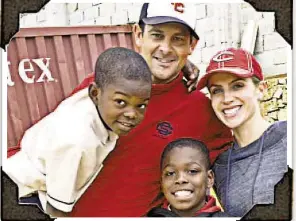  ?? COURTESY OF BOONE FAMILY ?? Aaron and Laura Boone (above) with Jeanel and Sergot during a visit to Haiti. Laura (below) with kids walking up a Haitian road.