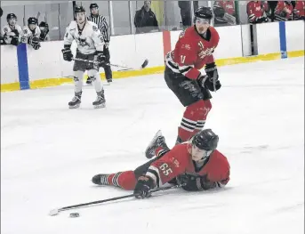  ?? SAM MACDONALD/THE NEWS ?? Robert Burrows of the Pictou County Scotians tries to hang onto the puck while falling to the ice in a Nova Scotia Junior Hockey League game played on Sunday in Trenton. Looking on is Scotians forward Morgan Timmons.