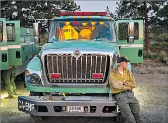  ?? Noah Berger Associated Press ?? A U.S. FOREST Service firefighte­r prepares to work an overnight shift battling the Lava fire. Beyond drought and heat, the fight is complicate­d by lava formations and conflict with pot growers.