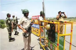  ??  ?? ROHTAK: Security forces deployed at main junctions stand guard near a jail where controvers­ial guru Ram Rahim Singh is awaiting sentencing, in Rohtak.—AFP