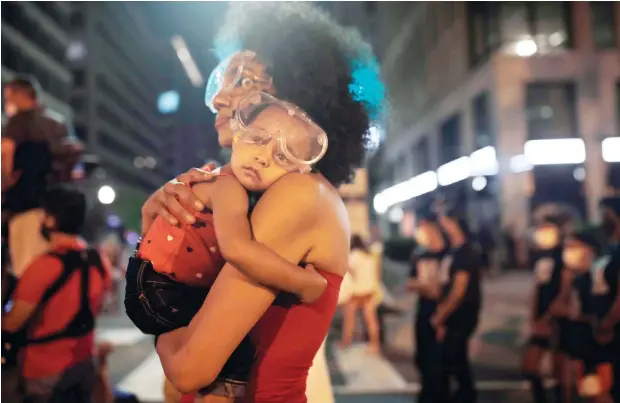  ?? (AP) ?? A sleepy Bonita wears protective goggles as she settles into her mother’s shoulder near the White House on June 23, amid continuing anti-racism demonstrat­ions following the death of George Floyd, a Black man who
was restrained by police in Minneapoli­s.