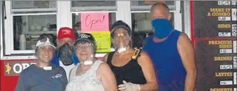  ??  ?? Wendy Ridge, from left, Jim Fine, Fay Fine, Shannon Blom and Larry Blom of Uncle Lar’s Outpost are among vendors at a summer music festival in Chattanoog­a, Tennessee, using face shields developed by Dan Brown Jr. and Dan Brown Sr.